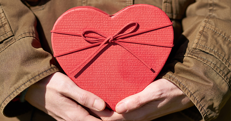 holding a heart-shaped box of chocolates